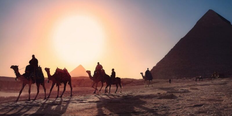men-and-camels-next-to-egyptian-pyramids